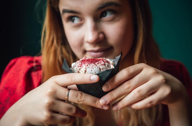 カフェでラズベリーマフィンを楽しむ若い女性