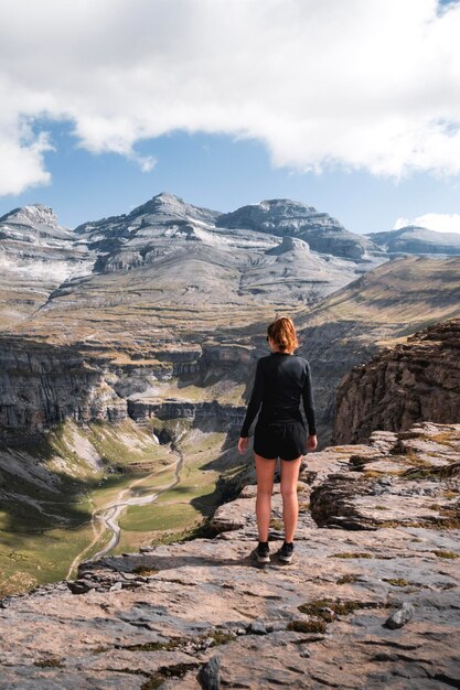 Young woman enjoys the views of the Monte Perdido canyon in summer in the Pyrenees