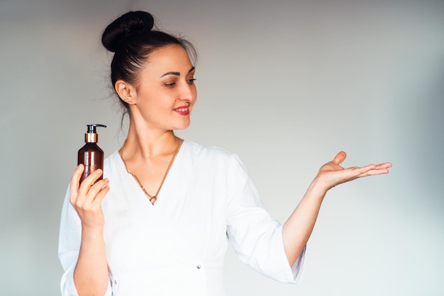 A young woman of European appearance in a white medical uniform with a massage jar in her hand Booking massage