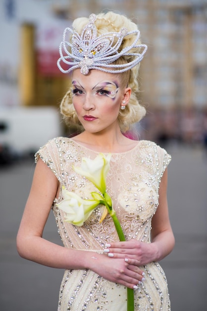 A young woman in an evening dress and an original hairstyle on the street