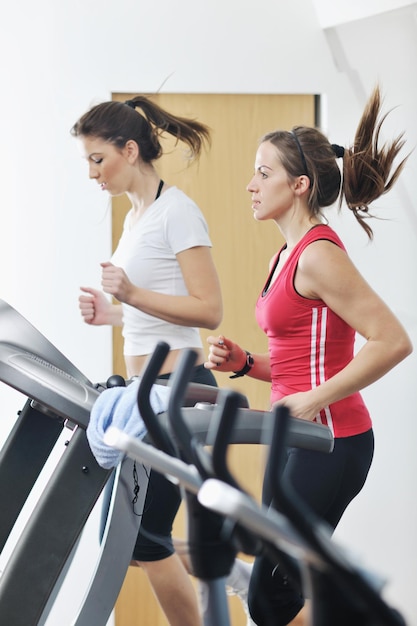 молодая женщина занимается фитнесом и тренируется во время бега на трассе в спортивном клубе
