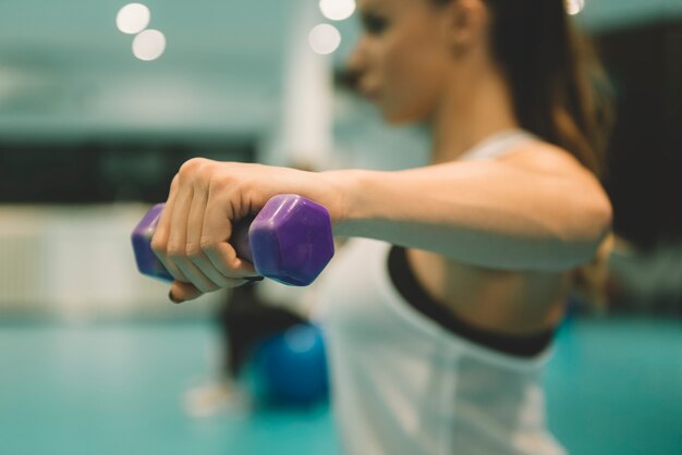 Young woman exercise with weights at the gym