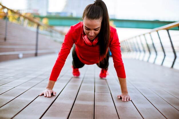 Young woman exercises on the promenade after running