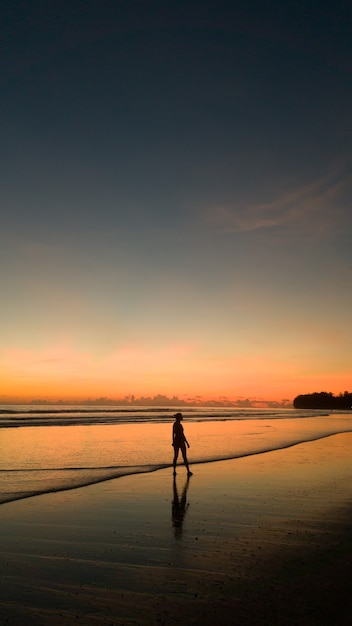 Photo young woman exercising on the beach at beautiful sunset