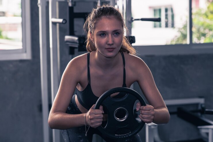 Photo young woman exercising at gym