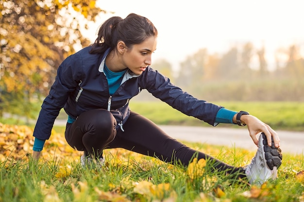 Young woman exercising at park during sunset