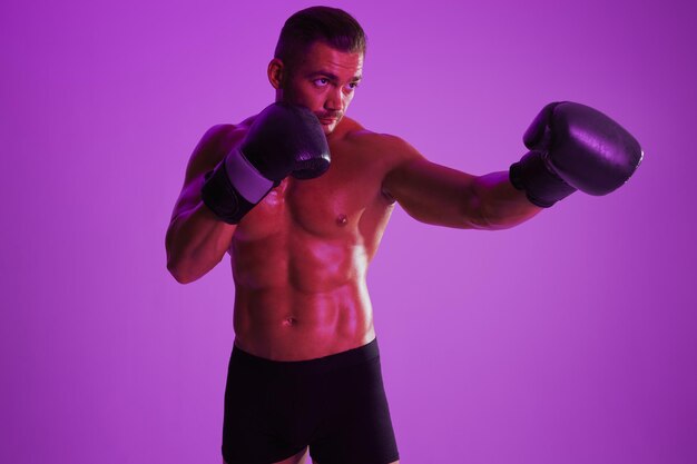 Young woman exercising with dumbbells against blue background