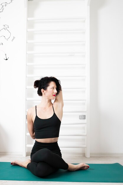 Photo young woman exercising yoga in her own apartment and enjoying her day