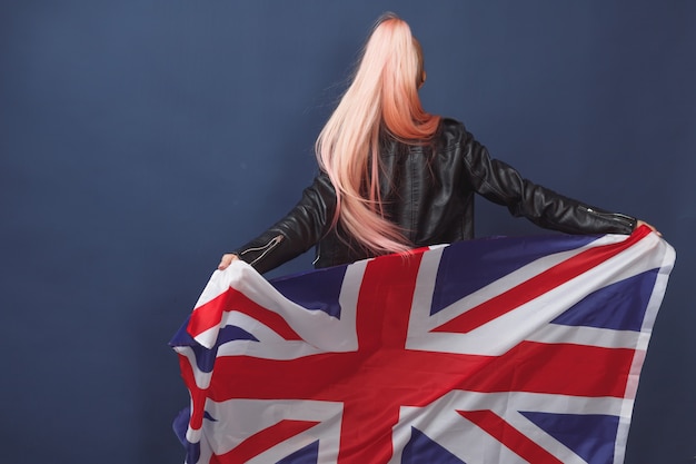 Young woman expat in eyeglasses with great britain flag. Studio shot. English language hipster teacher