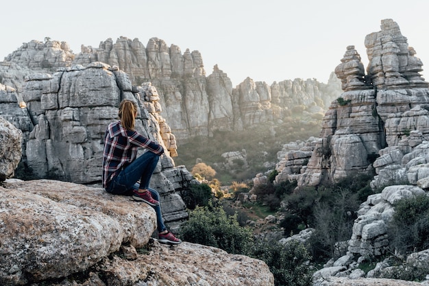 Foto esploratore di giovane donna seduta, guardando le montagne. concetto di avventura, escursione e gite.