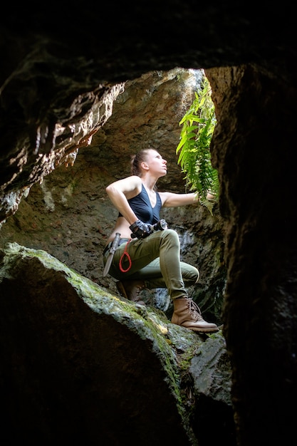 Young woman explores ancient cave