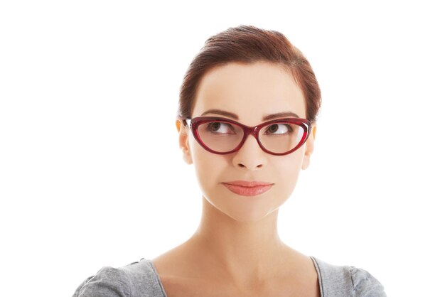 Young woman in eyeglasses standing against white background