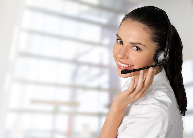 Young woman face with headphones, call center or support concept