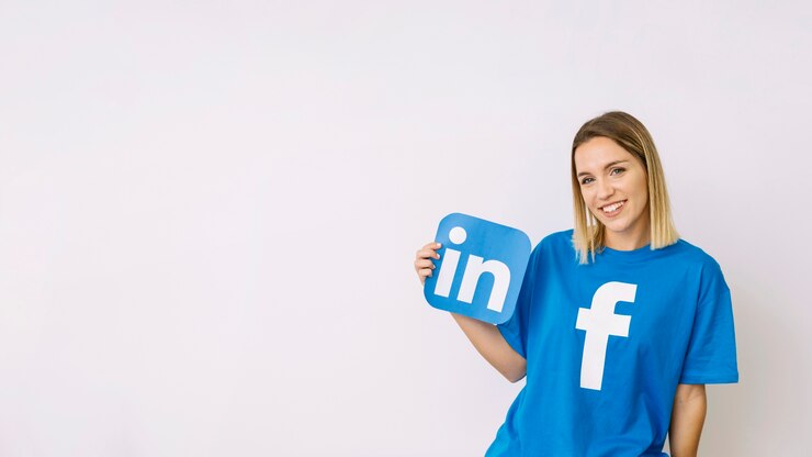 Фотография молодая женщина в футболке facebook, удерживая linkedin значок