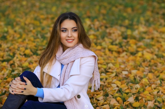 Young woman and fall yellow maple garden background. free space
