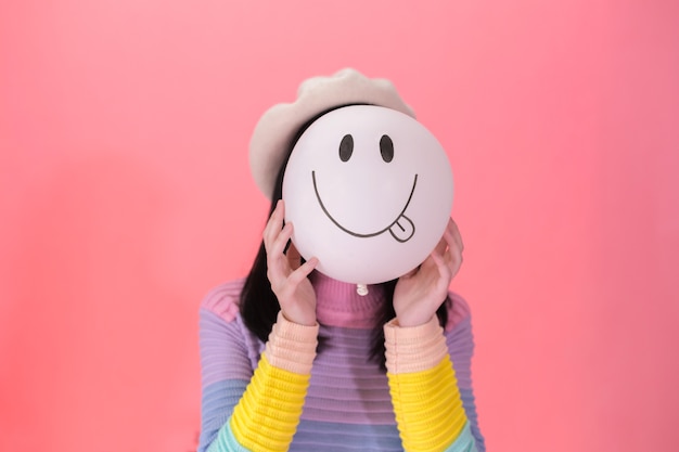 Photo young woman in fashionable style holding a positive emotion of balloon