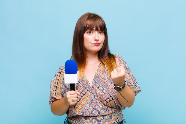 Young woman feeling angry, annoyed, rebellious and aggressive, flipping the middle finger, fighting back