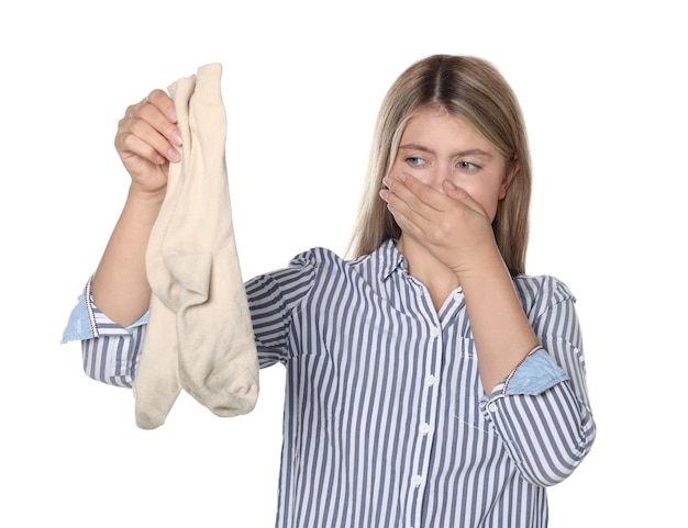 Young woman feeling bad smell from dirty socks isolated on white