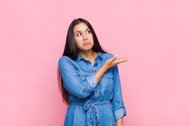 Young woman feeling confused and clueless, wondering about a doubtful explanation or thought