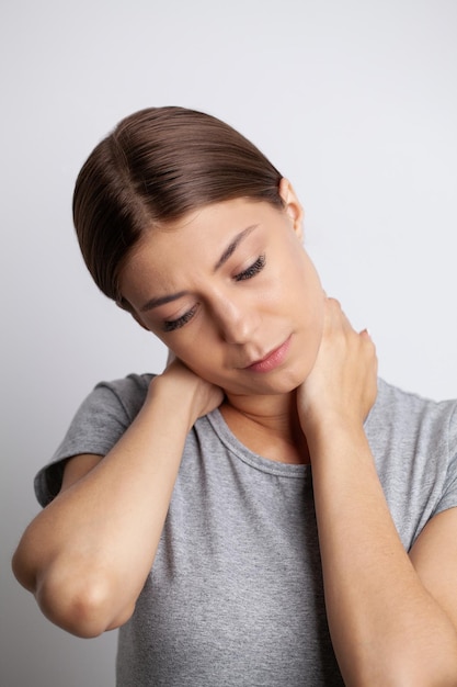 Young woman feeling exhausted and suffering from neck pain health concept