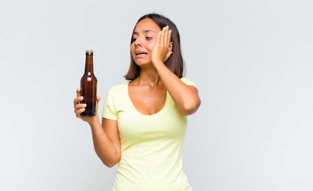 Young woman feeling happy, excited and surprised, looking to the side with both hands on face