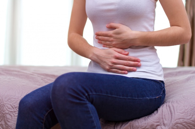 Young woman feels abdominal pain during the period menstruation