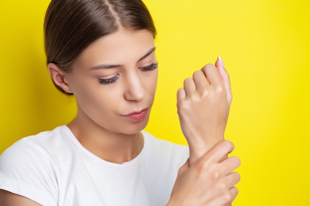 Young woman feels severe pain in her hand