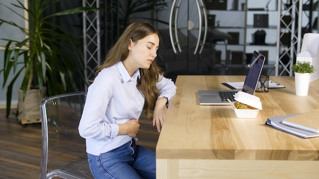 Young woman feels a sharp pain in the upper abdomen after a quick snack diabetes