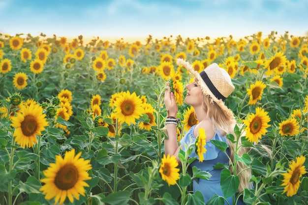 Giovane donna in un campo di girasoli in fiore