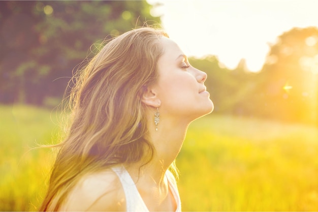 young woman on field under sunset light