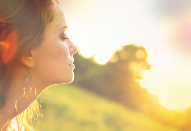 Young woman on field under sunset light