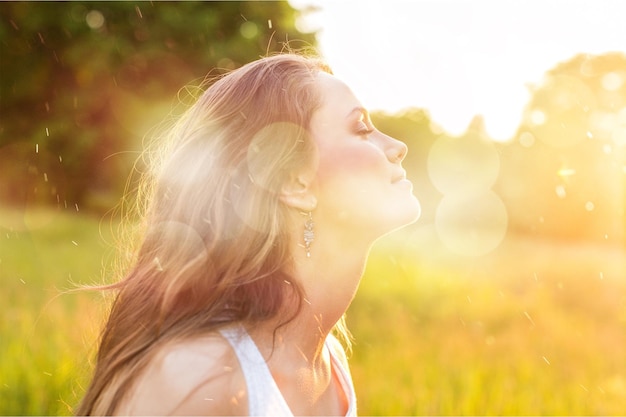 young woman on field under sunset light