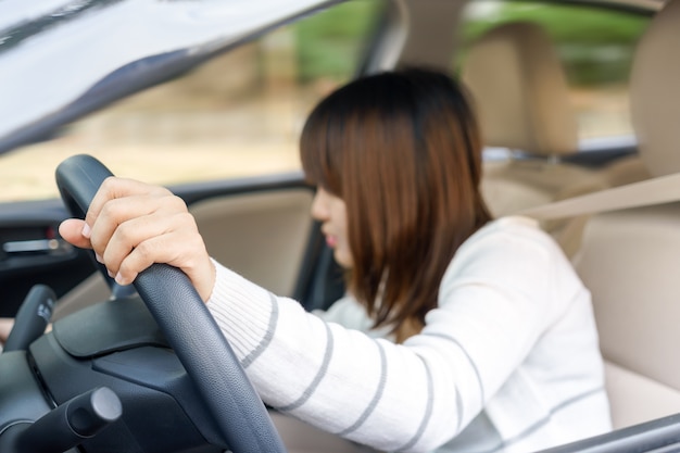 運転中に不自然に車の引き出しの前で何かを見つける若い女性 -  accide