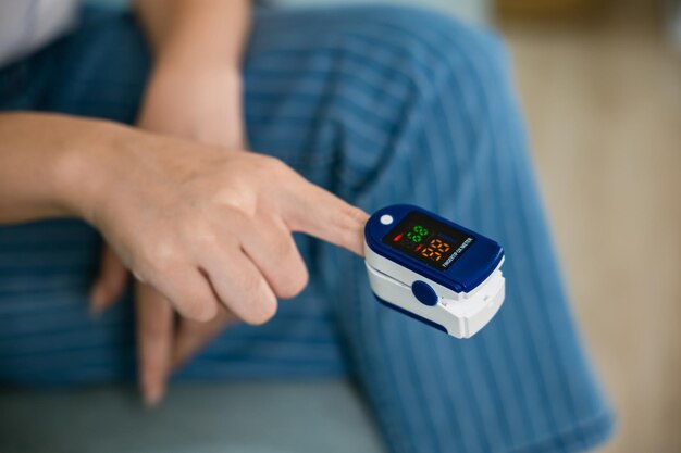 Photo young woman finger inserted into the pressure oximeter to assess health