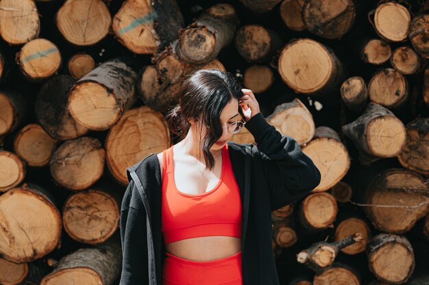 Young woman in fitness clothes thinking in front of a pile of trunks