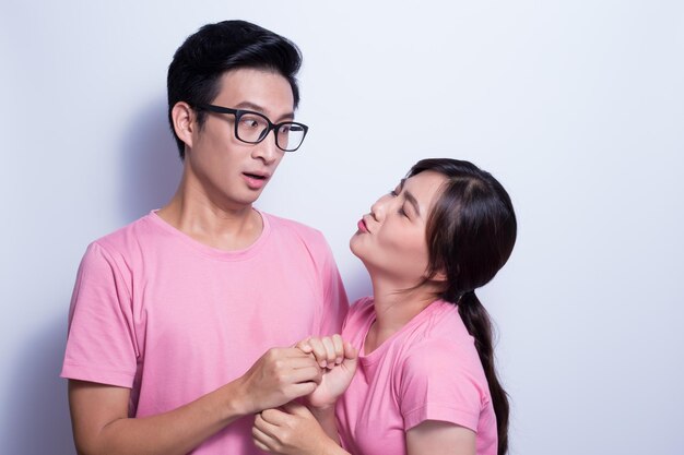 Young woman flirting with man against white background