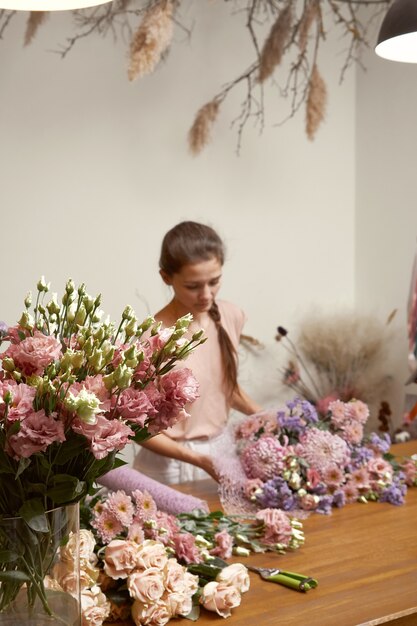 美しい花束を作る彼女のスタジオで若い女性の花屋