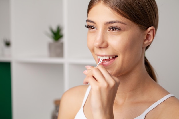 Young woman flossing her teeth in bathroom