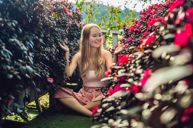 花の温室で若い女性。明るい熱帯の花。