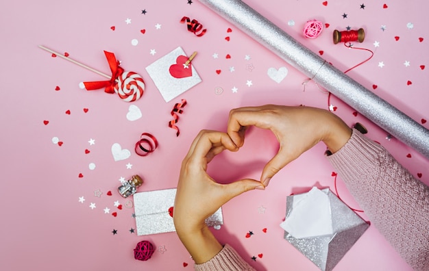 Young woman forming shape of heart with her fingers