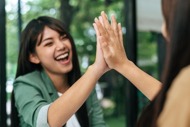 Photo young woman and friend doing high five with glad