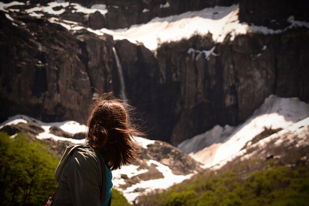 Молодая женщина сзади смотрит на водопад, водопад возле Cerro Tronador в аргентинской Патагонии