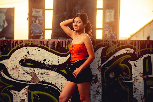 Young woman in front of a graffiti mural