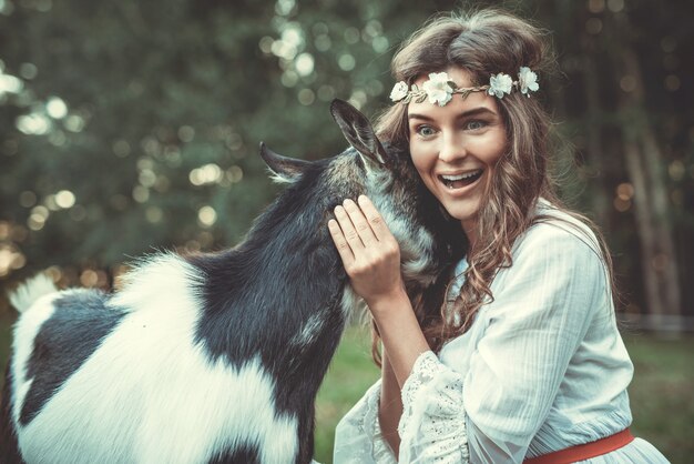 Young woman and funny friendly goat