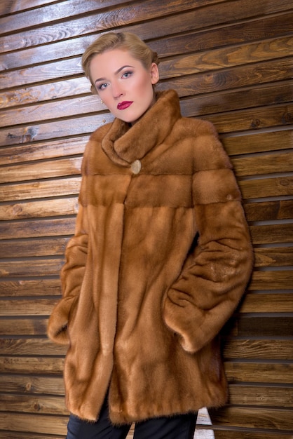 インテリアに天然毛皮で作られた毛皮のコートを着た若い女性。