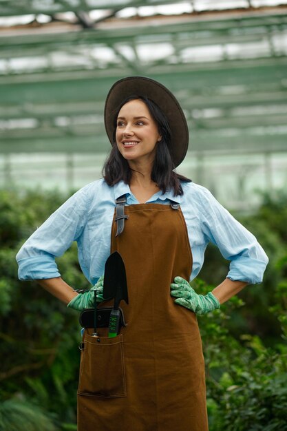 Photo young woman gardener proud of beauty of her own greenhouse