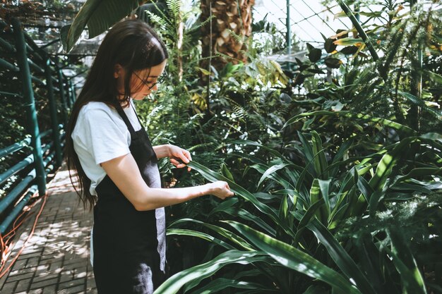 Молодая женщина-садовник, работающая в садовом центре