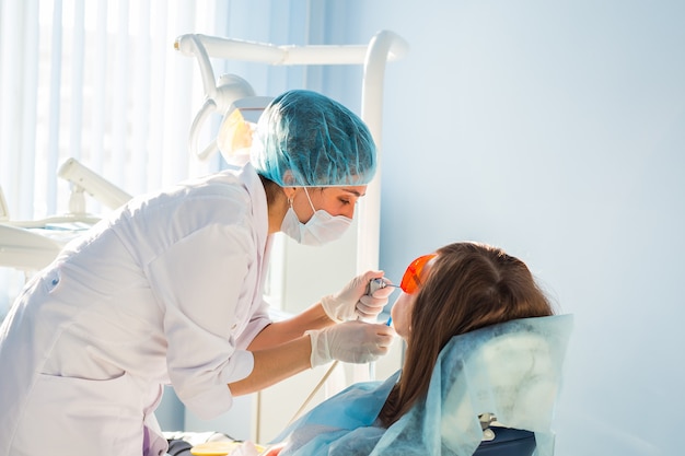 Молодая женщина, получающая стоматологическое лечение. Стоматологическая клиника