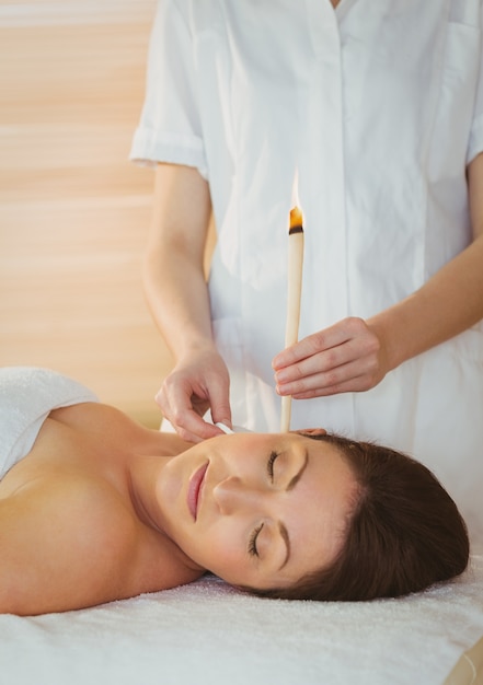 귀 candling 치료를 받고 젊은 여자