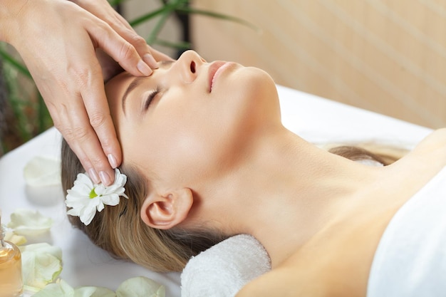 Young woman in getting facial massage in spa salon